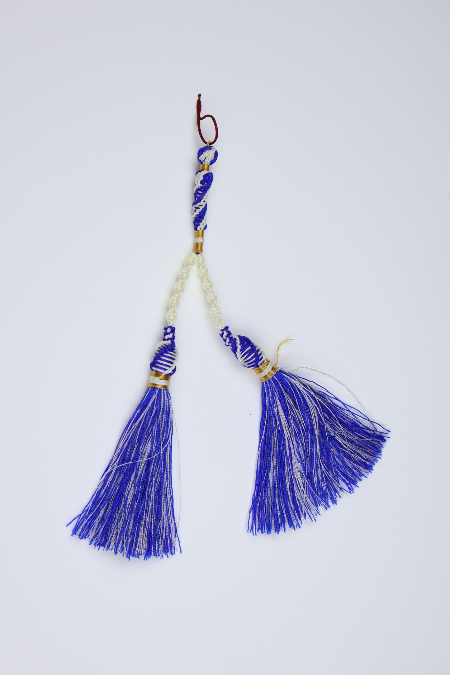 A traditional Japanese ornaments (kanzashi) featuring vibrant blue and white silk tassels, white beads, and gold-toned metal accents, displayed on a clean white background.