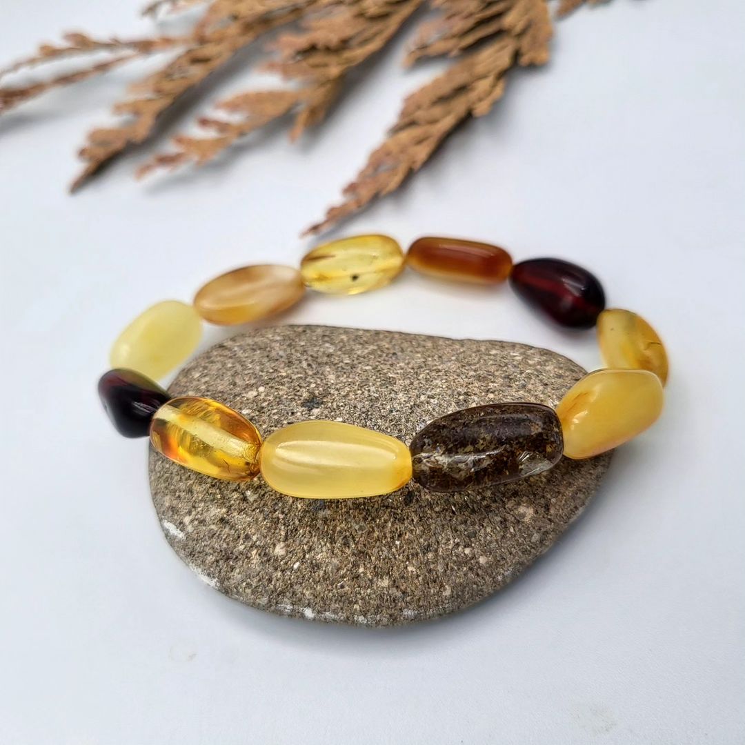 Baltic amber bracelet with smooth, polished olive beads, showcasing natural color variations.