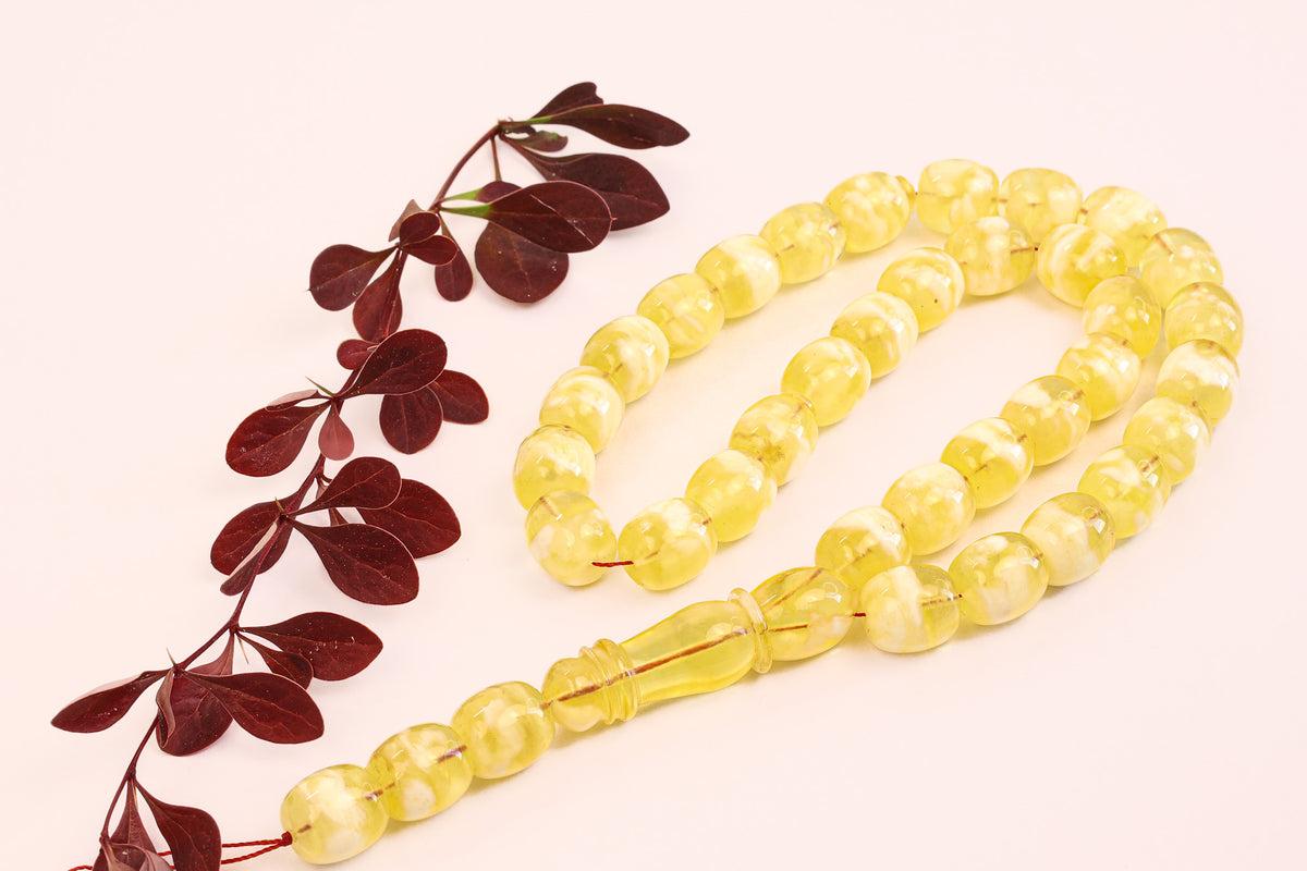Detailed shot of the 'Butterscotch' amber rosary tassel and the signature 'Imam' bead.