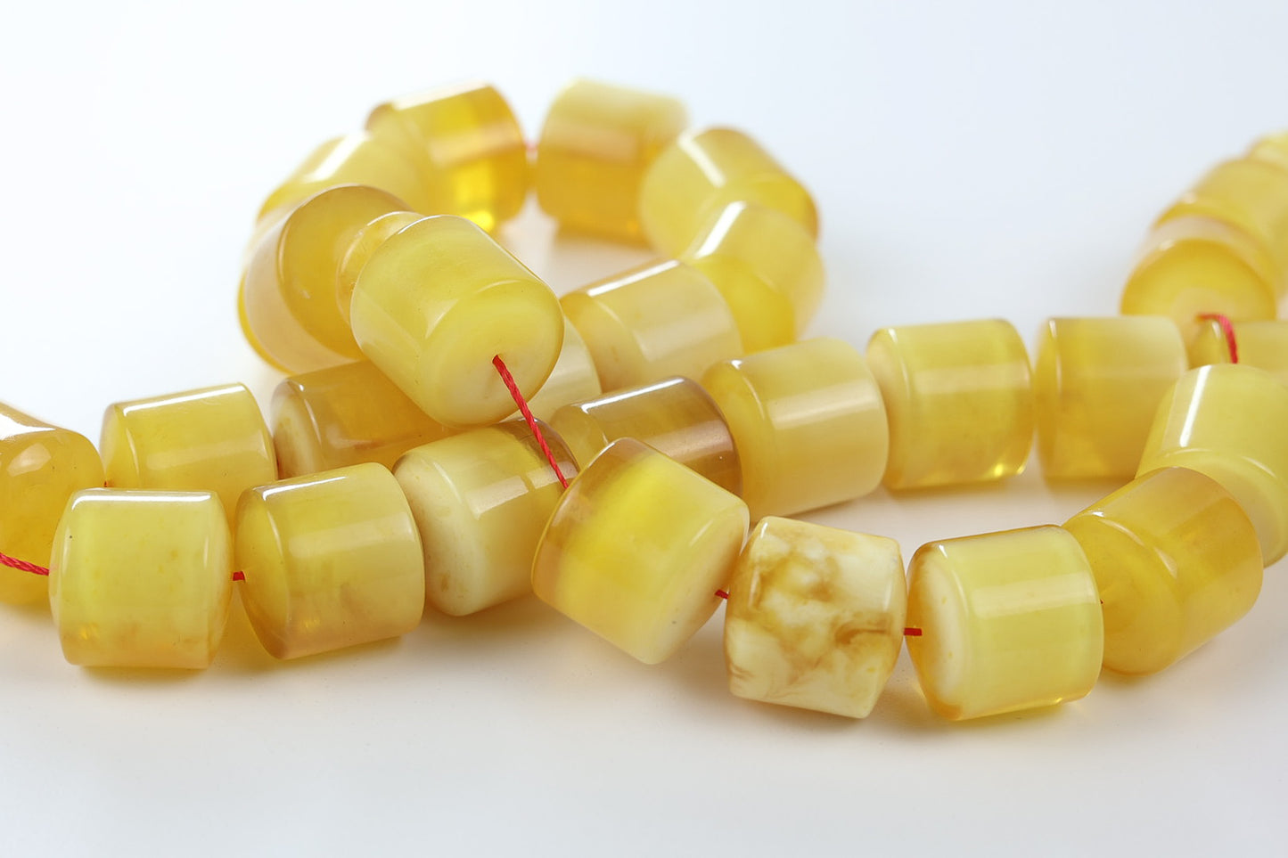 Tetibel Pressed Baltic amber rosary in butterscotch yellow with polished barrel beads and red thread, handmade luxury prayer beads