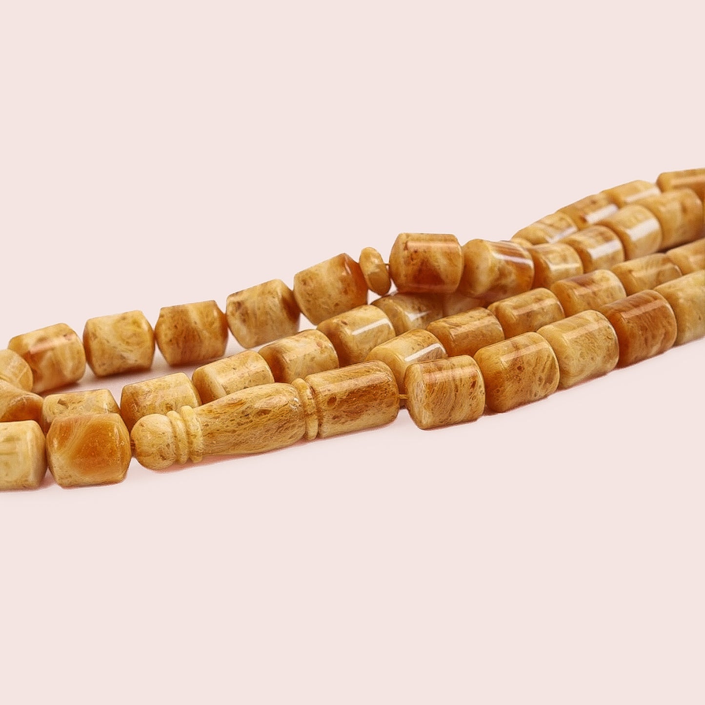 Detailed view of imam and the 10x8mm amber beads and the barrel-shaped main spacer (Imam) of the Tetibel prayer chain, highlighting the natural resin inclusions.