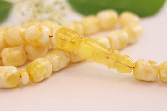 Close-up of the Tetibel butterscotch Baltic amber beads with their distinctive creamy and translucent patterns, showcasing the Imam (leader bead).
