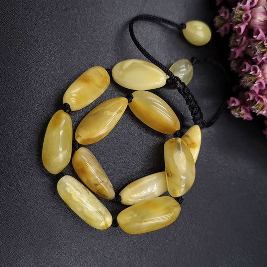 Detailaufnahme der milchig-gelben Bernstein-Perlen, zeigt die natürliche Textur und die hochwertige Politur.