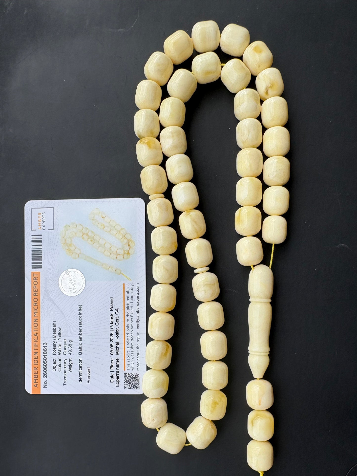 Tetibel Baltic Amber Mesbah rosary featuring 48 certified pressed white and yellow barrel beads measuring 12x11mm, weighing 49.38g, showing unique minor organic imperfections with an Amber Experts certificate.