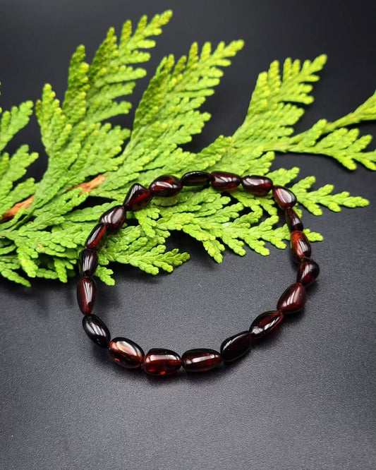 Nahaufnahme des transparenten Bernsteinarmbands mit großen, glänzenden Kirschbernstein-Perlen.