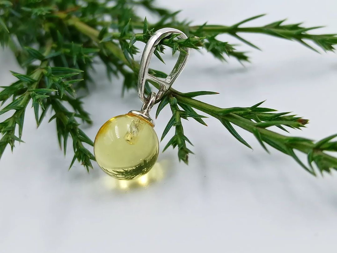 Natural Baltic amber sphere pendant in silver with honey tone