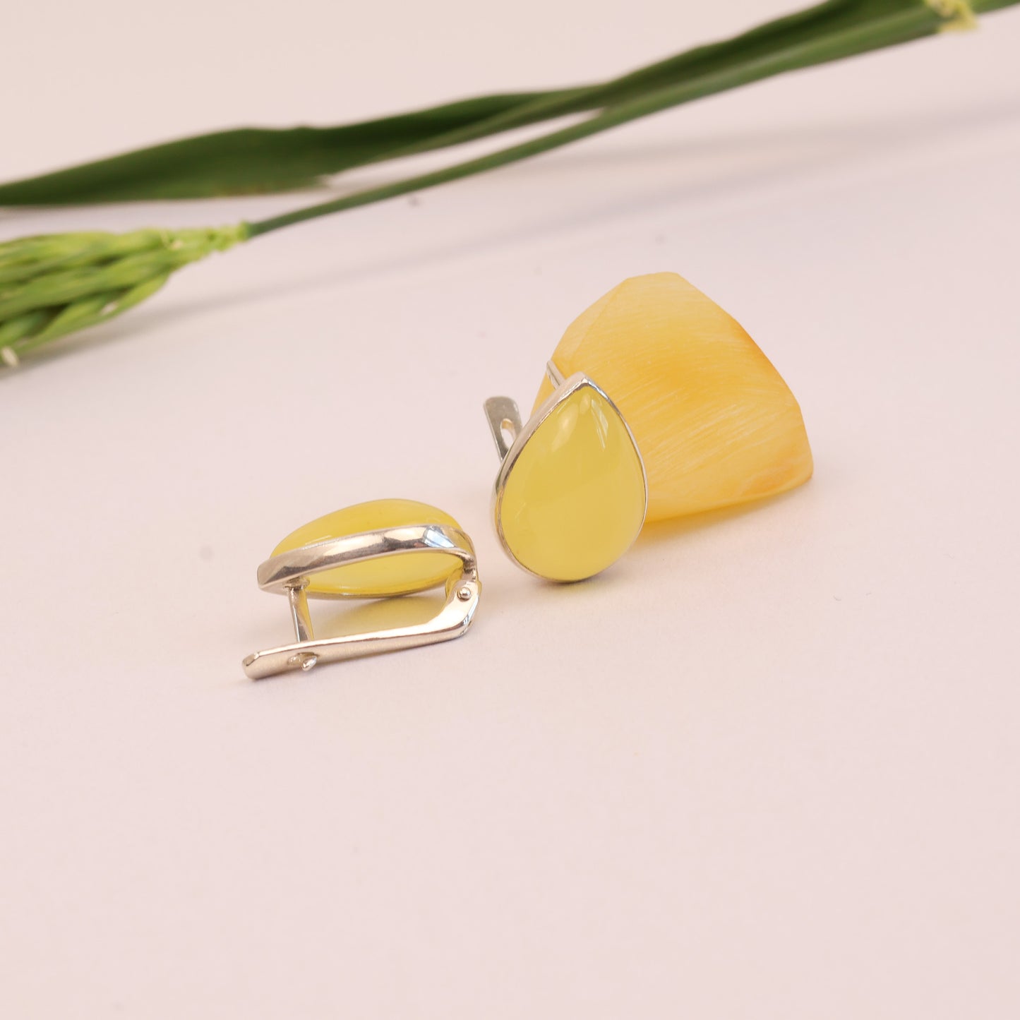 Yellow earrings with silver accents on a light background