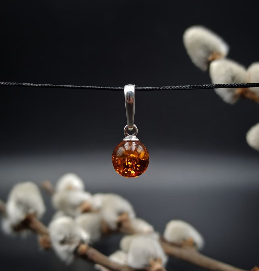 Cognac Baltic amber sphere pendant in silver with natural inclusions