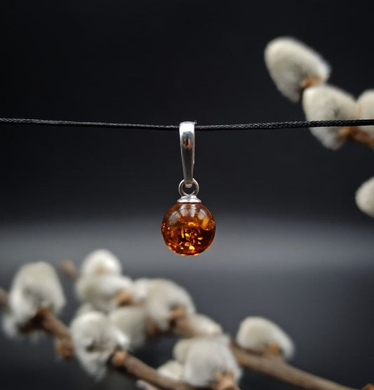 Cognac Baltic amber sphere pendant in silver with natural inclusions