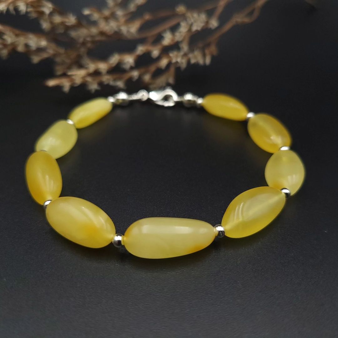 Close-up of Tetibel light yellow Baltic amber oval bead bracelet with 925 sterling silver lobster clasp