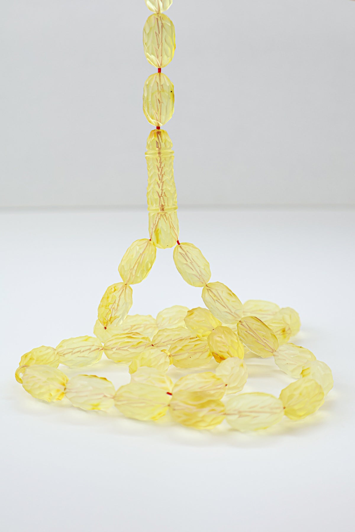Handcrafted yellow succinite amber tasbih featuring 36 authentic 16x9.5mm handmade carved beads with natural imperfections, weight 32.60 grams.
