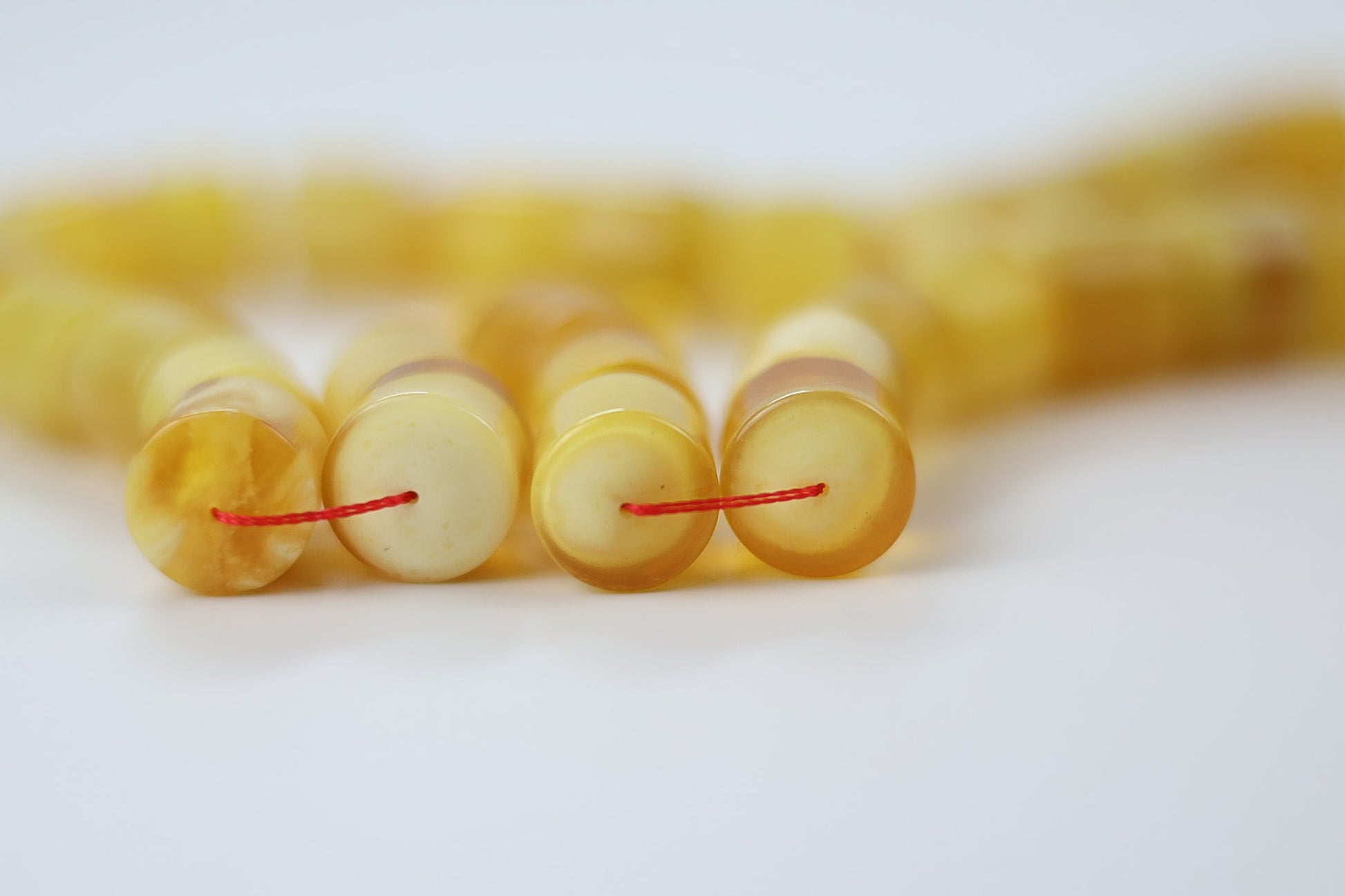 Natural texture of pressed Baltic amber beads in yellow butterscotch color
