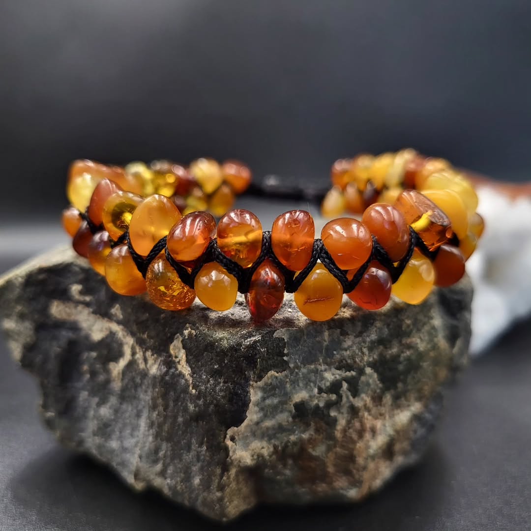 Gesamtansicht des Tetibel Bernstein Armbands mit Makramee-Knoten und verstellbarem Verschluss, zeigt die Natursteine in warmer Farbgebung.