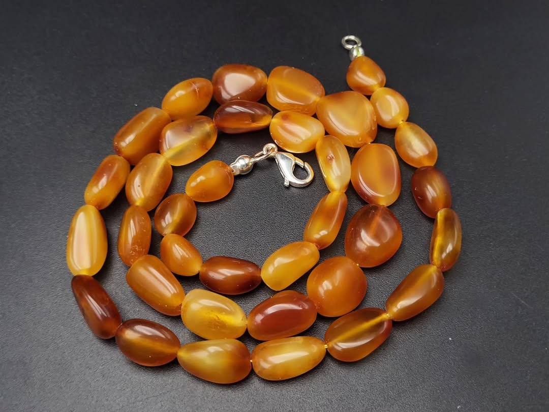 Necklace with amber-colored beads on a dark background