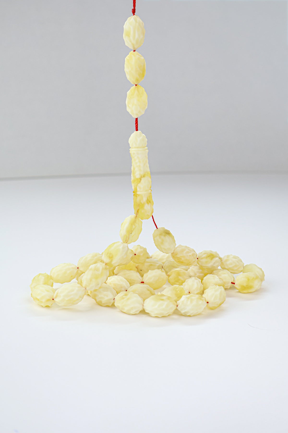Handcrafted yellow and white succinite amber tasbih featuring 48 authentic 15.5x10mm handmade carved beads, weight 43.37 grams.