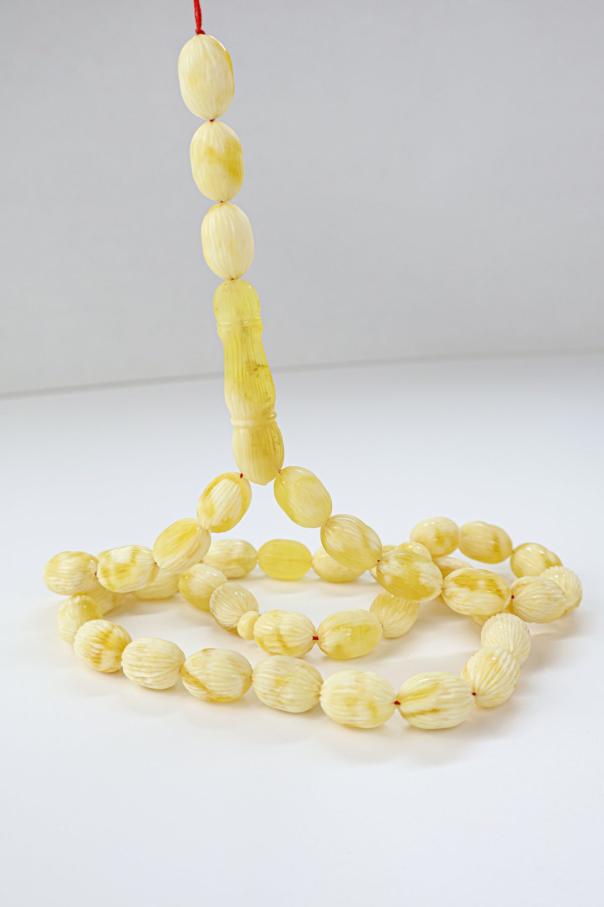 Handcrafted yellow and white succinite amber tasbih featuring 42 authentic 15.5x10.5mm handmade carved beads, weight 45.50 grams.