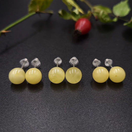Milch-gelbe Bernstein Ohrstecker mit 925 Sterling Silber Stiften. Ansicht betont die polierten, runden Lemon Bernstein Kugeln.

