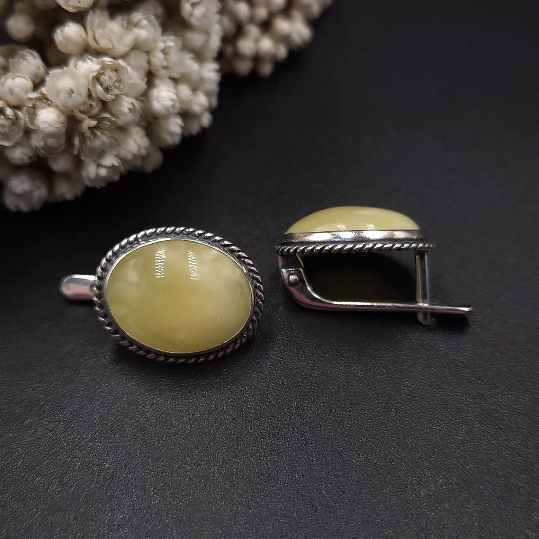 Close-up view of milky yellow amber sterling silver earrings, Back view of Tetibel oval amber earrings with silver lever-back closure