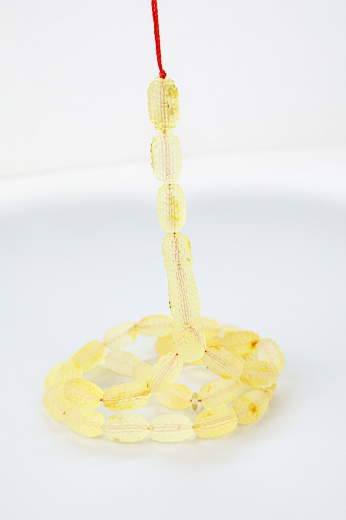 Handcrafted yellow succinite amber tasbih featuring 36 authentic 15x8.5mm handmade carved beads with natural imperfections, weight 25.90 grams.