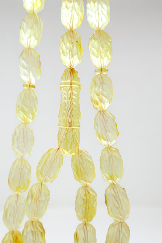 Authentic grooved hand-carved translucent yellow Baltic amber misbaha strand displaying natural minor character marks and a matching carved amber imam.