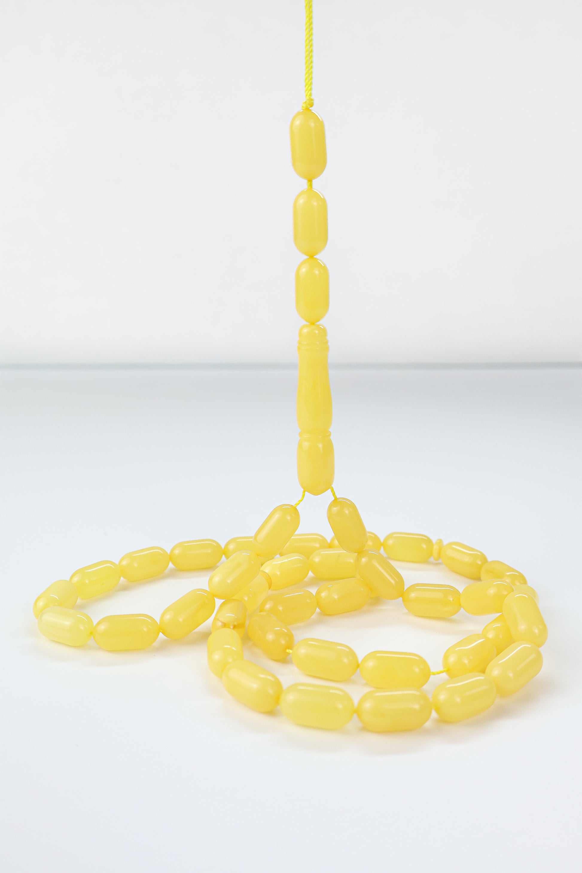 Natural opaque Baltic amber Mesbah featuring polished lemon yellow oval amber beads.