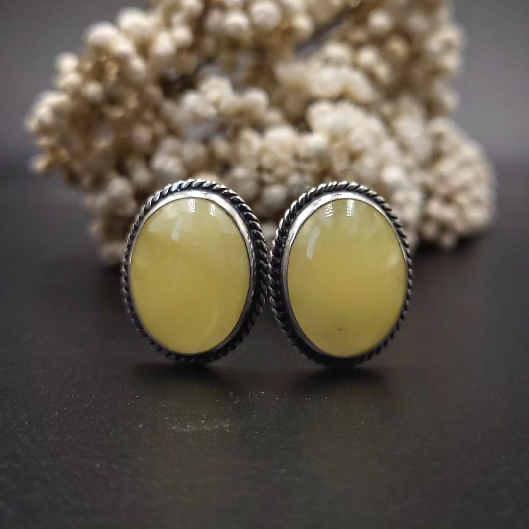 Close-up view of milky yellow amber sterling silver earrings, Back view of Tetibel oval amber earrings with silver lever-back closure