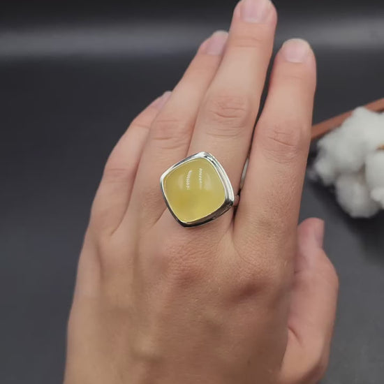 Handcrafted sterling silver ring featuring a polished translucent yellow natural Baltic amber cushion stone by Tetibel.