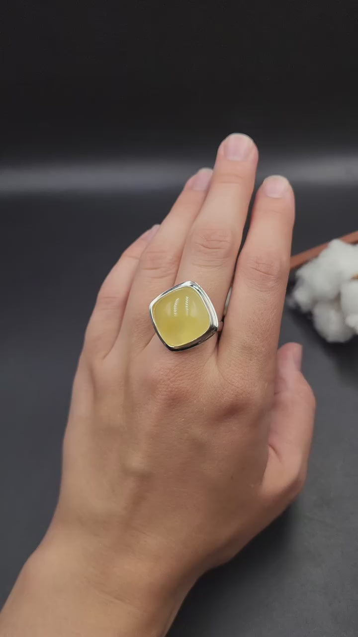 Handcrafted sterling silver ring featuring a polished translucent yellow natural Baltic amber cushion stone by Tetibel.