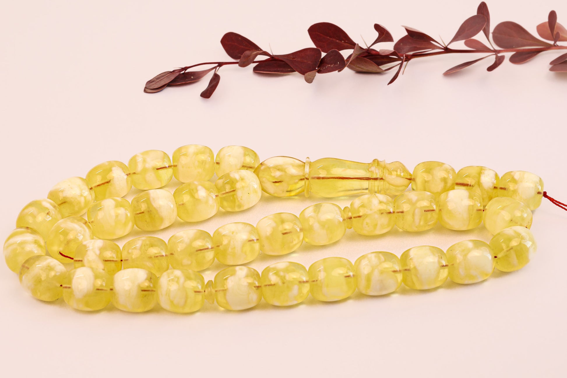 Close-up of certified Baltic amber Tesbih (سبحة كهرمان بلطيقي). Features opaque, milky yellow succinite beads.
