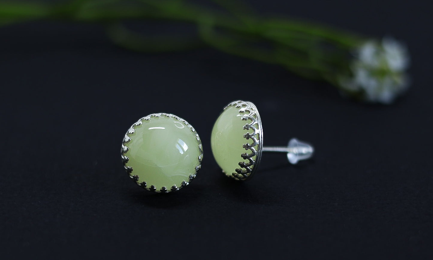 Tetibel's handcrafted Baltic amber and silver stud earrings, emphasizing the unique texture of the silver bezel and the lightness of the 2.3g design