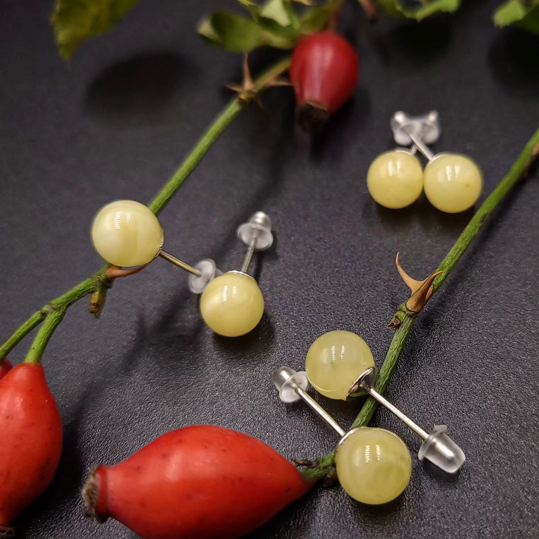 Drei Paare Lemon Baltischer Bernstein Kugel-Ohrstecker (⌀7mm, ⌀8mm, ⌀9mm) mit Silberstiften auf schwarzem Hintergrund.