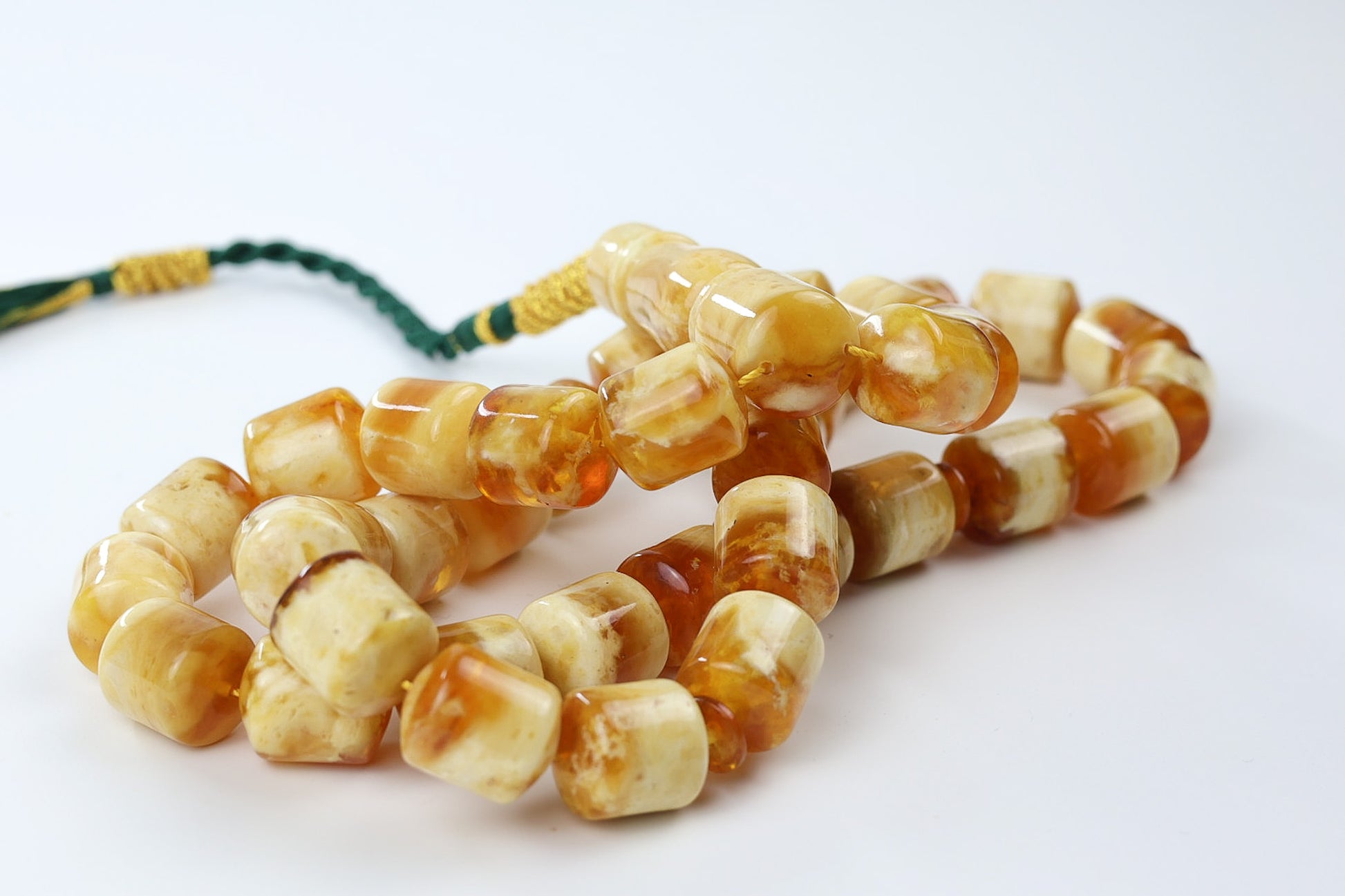 Detail view of square pressed amber beads in warm honey and cognac mix, polished finish