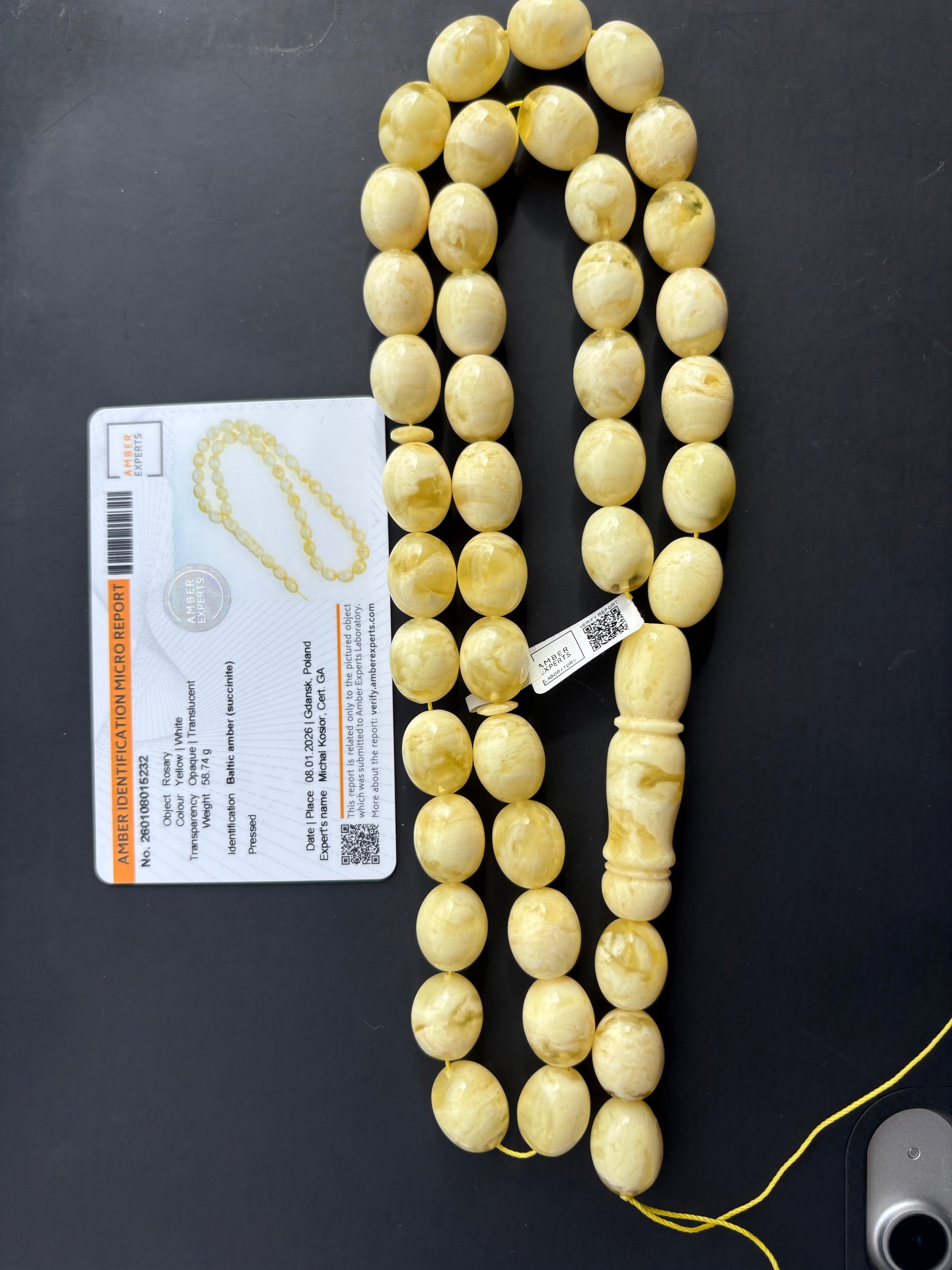Tetibel 42-bead pressed Baltic amber rosary with 15x12mm yellow and white marbled oval beads alongside its official authenticity micro report.