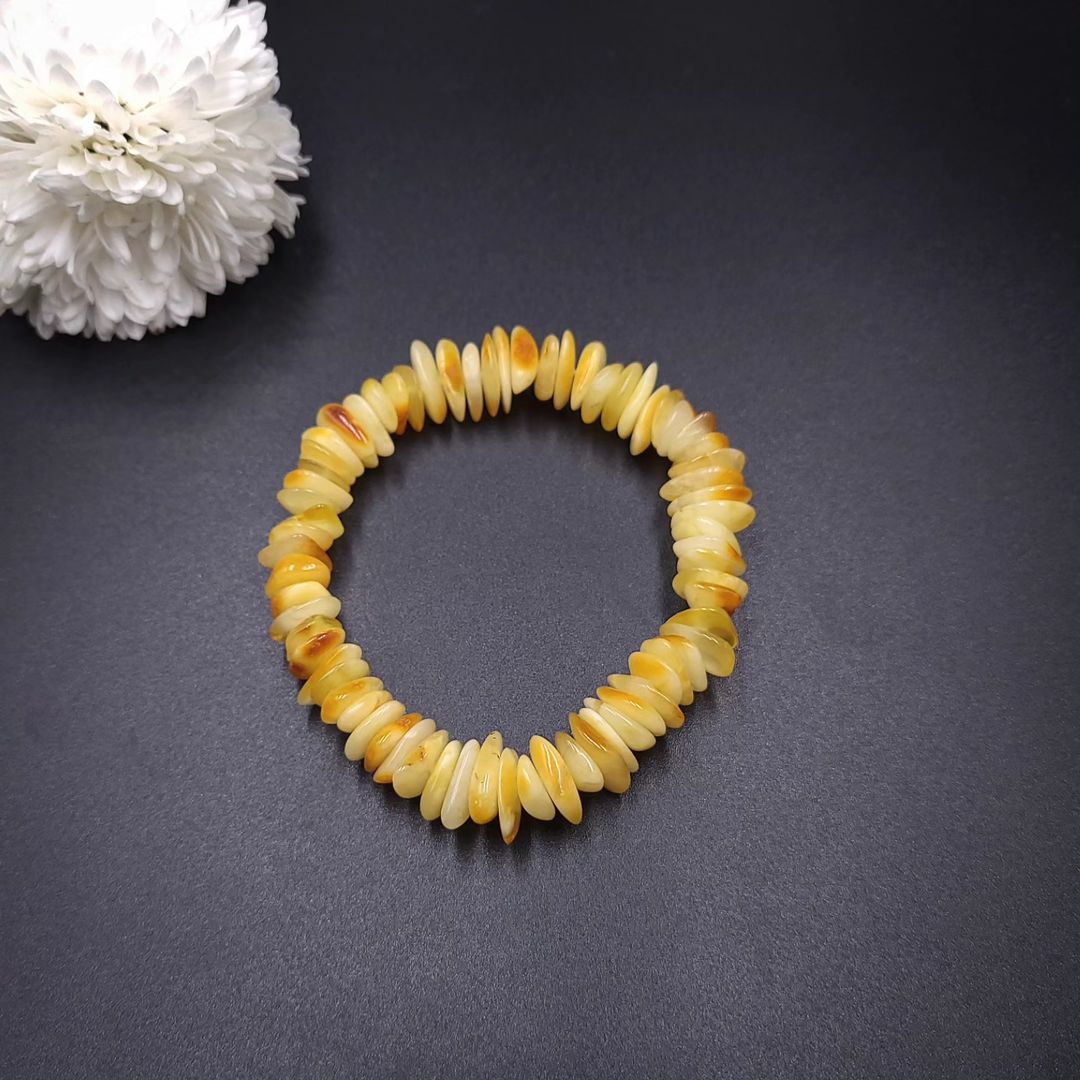 Yellow amber chip bracelet styled on a woman's wrist, showcasing the natural light honey color.